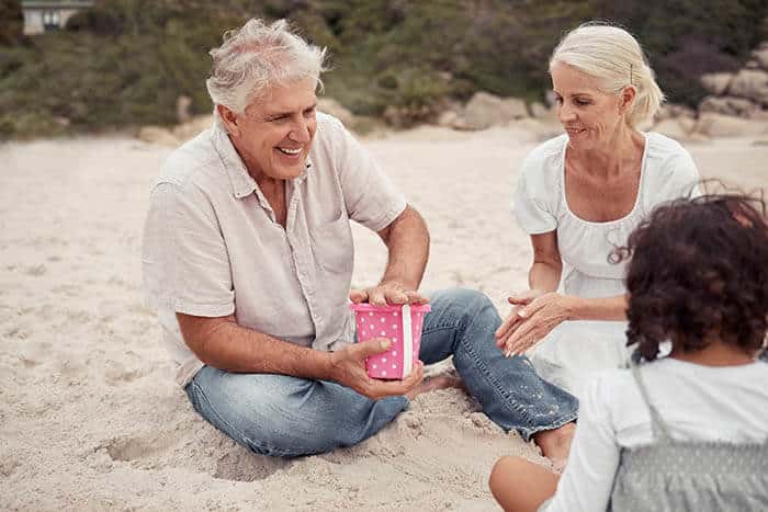 Grandparents playing with their grandkids on a beach